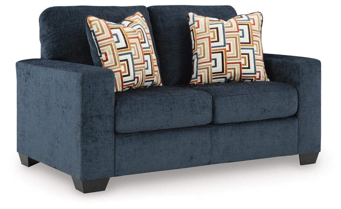 Alyesmore Loveseat by Ashley Furniture, angled view showing plush beige fabric and cushioned armrests for cozy seating.