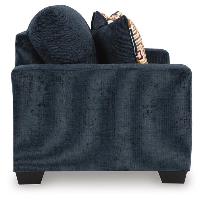 Ashley Furniture Aviemore loveseat with plush beige upholstery and tapered wooden legs, shown from the side view.
