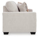 A Ashley Furniture Aviemore loveseat with plush beige upholstery and wooden legs, shown from a side angle.