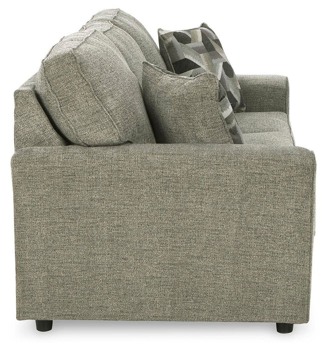 Ashley Furniture Cascilla Sofa with plush fabric and wide armrests, shown from a side view in a modern living room setting.