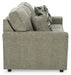 Ashley Furniture Cascilla Sofa with plush fabric and wide armrests, shown from a side view in a modern living room setting.