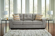 Ashley Furniture Larimer living room set with sofa, loveseat, and armchair, featuring neutral upholstery and wooden legs.