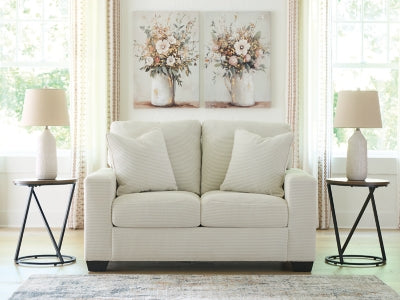 Greenbriar loveseat by Ashley Furniture with plush green upholstery and comfortable cushioning, shown in a cozy living room setting.