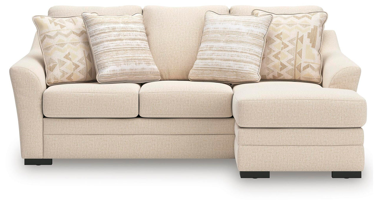 Ashley Furniture Lango Sofa Chaise Sleeper with beige upholstery and plush cushions, viewed from the front.