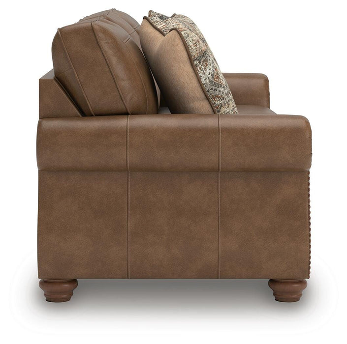 Ashley Furniture Chasemore sofa with beige upholstery, plush cushions, and wooden legs, shown from a side angle.