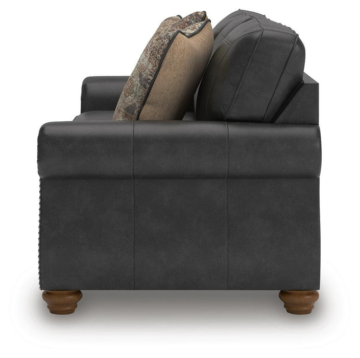Ashley Furniture Chasemore Sofa with beige fabric and plush armrests, shown from the side.