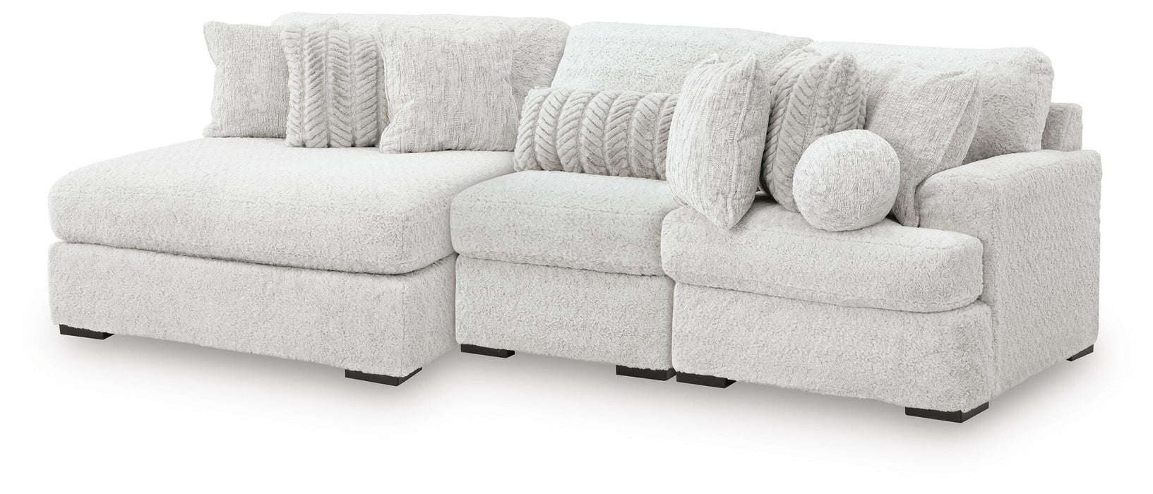 Ashley Furniture Cuddle Plush sectional with chaise, beige fabric, and plush cushions, shown from an angled side view.