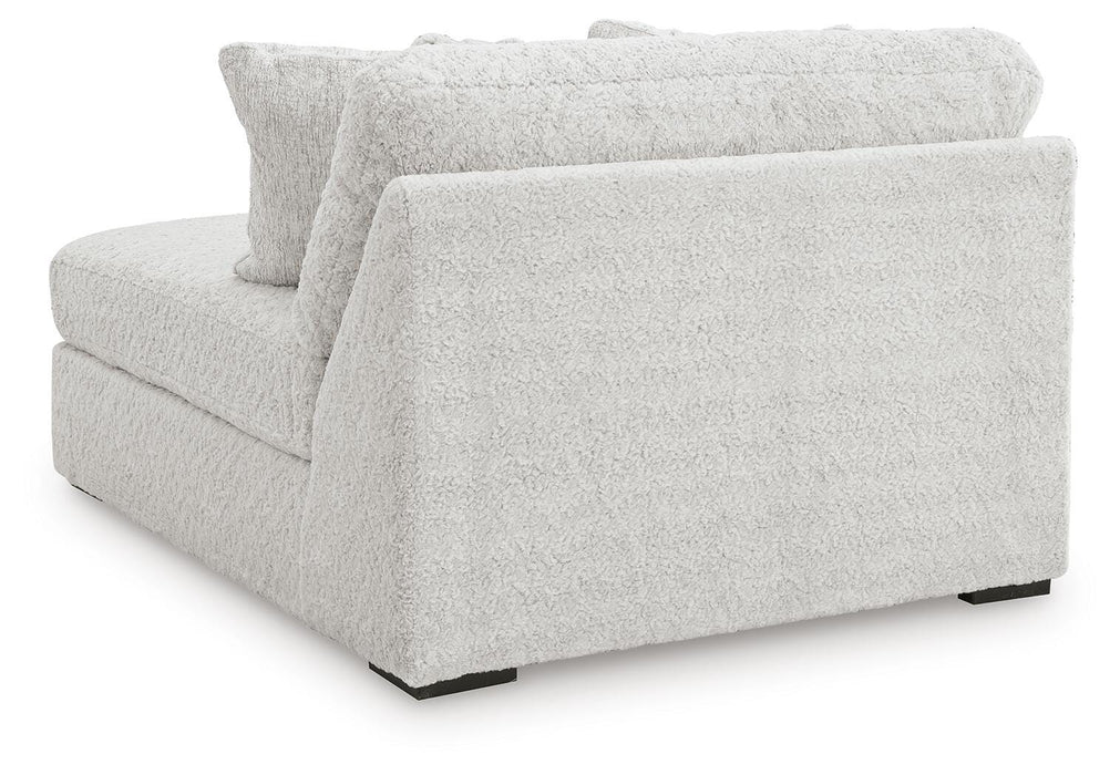 Back view of Ashley Furniture Cuddle Plush sectional with chaise, featuring soft fabric and plush cushions for comfortable seating.
