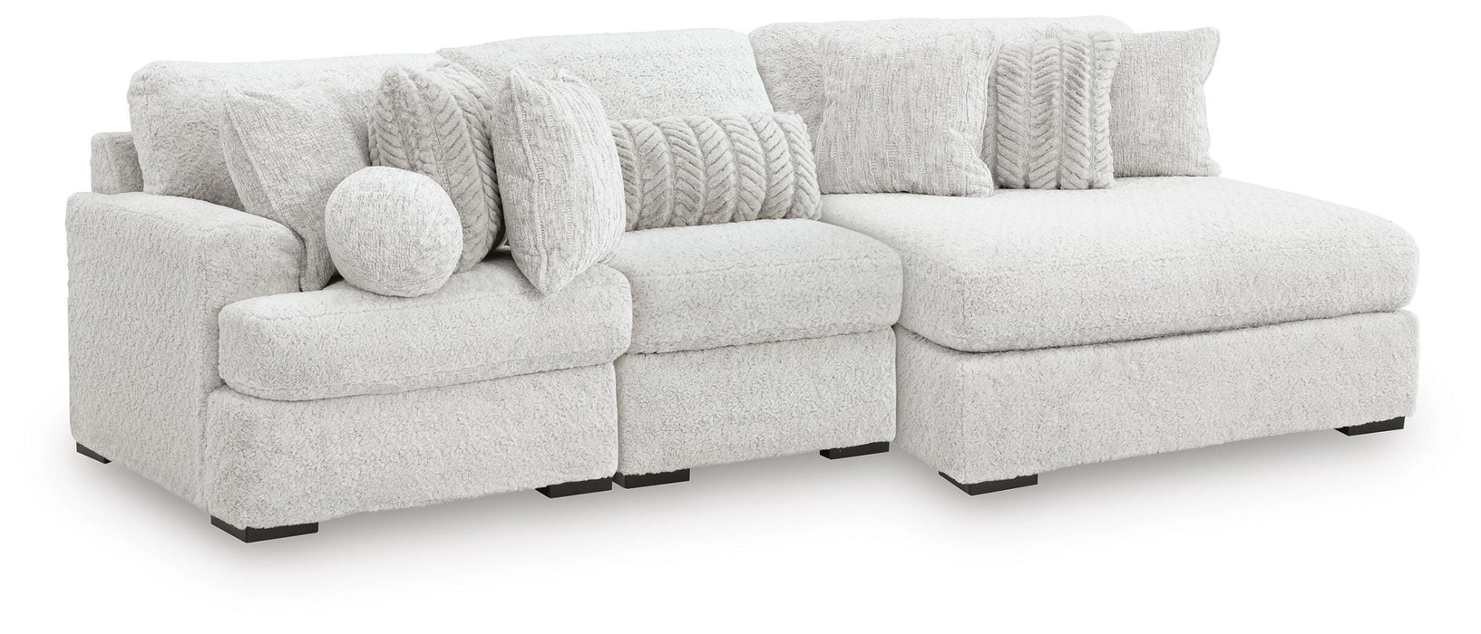 Ashley Furniture Cuddle Plush Sectional with Chaise, beige fabric, with plush cushions and a spacious chaise lounge, angled view.