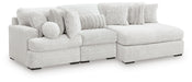 Ashley Furniture Cuddle Plush Sectional with Chaise, beige fabric, with plush cushions and a spacious chaise lounge, angled view.