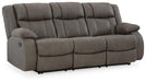 Ashley Furniture First Base reclining sofa shown from an angled view, featuring plush cushions and a reclining mechanism.