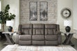 First Base reclining sofa by Ashley Furniture featuring plush cushions and a modern design, shown in a closed reclining position.