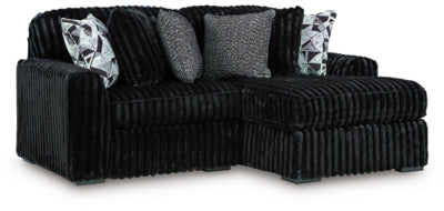 Ashley Furniture Midnight-Madness sectional with chaise, featuring plush cushions and modern design in a stylish living room setup.