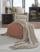Ashley Furniture Anawood throw blanket with a cozy, woven texture in neutral tones, draped over a surface.