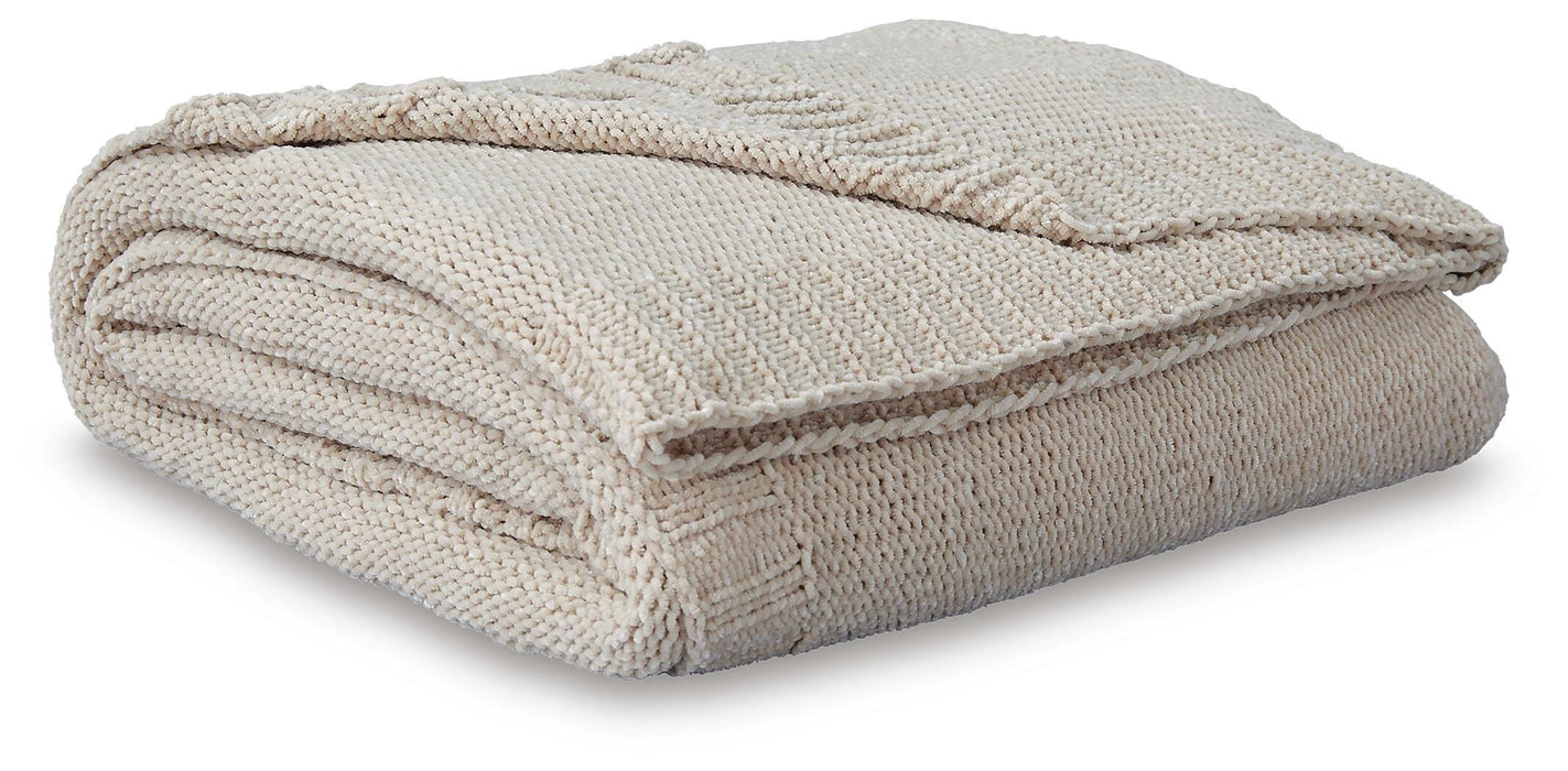 Soft woven Ashley Furniture Anawood throw blanket displayed draped over a sofa in a cozy living room setting.