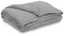 Ashley Furniture Anawood throw blanket featuring a cozy woven design, perfect for adding warmth and style to your living space.