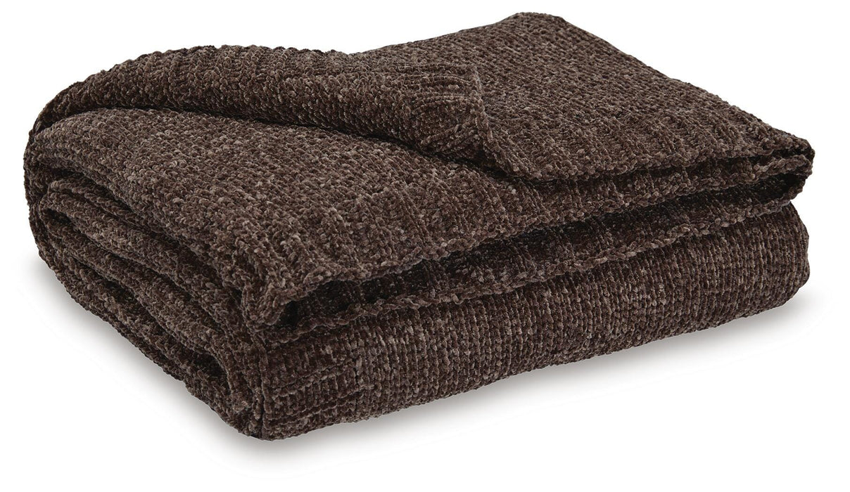 Ashley Furniture Anawood throw blanket featuring a cozy, woven design in neutral tones, perfect for adding warmth and style to a room.