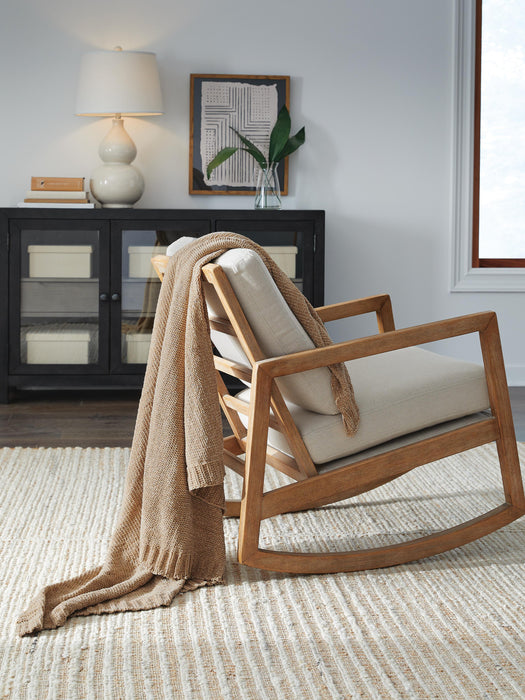 Ashley Furniture Anawood Throw blanket with a cozy, textured fabric in earthy tones, casually draped on a sofa.