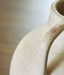 Ashley Furniture Justy Vase, decorative ceramic vase with a textured finish and neutral tones, shown in a close-up detail.