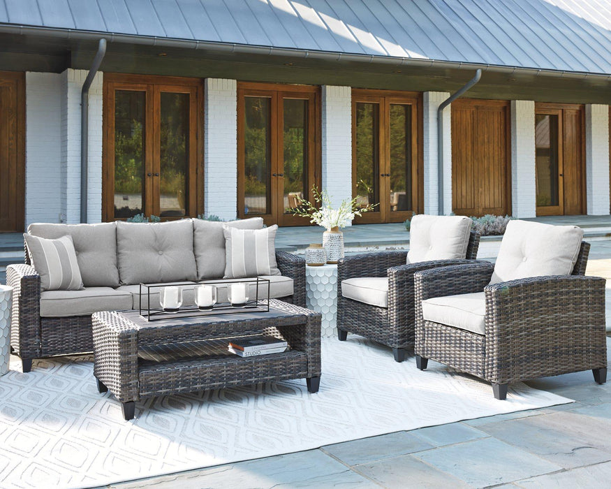 Cloverbrooke 4-piece outdoor conversation set by Ashley Furniture with cushioned seats and a coffee table for patio relaxation.
