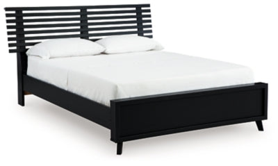 Ashley Furniture Danziar Queen Slat Bed with wooden frame and slatted headboard, shown from an angled side view.