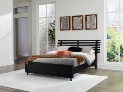 Ashley Furniture Danziar Queen Slat Bed with wooden slats and a classic headboard, showcasing its elegant design.