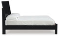 Ashley Furniture Danziar Bed with beige upholstered headboard and wooden frame, shown from a side angle.