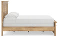 Ashley Furniture Makidern bed with a wooden frame and neutral upholstery, shown from a side angle in a modern bedroom setting.