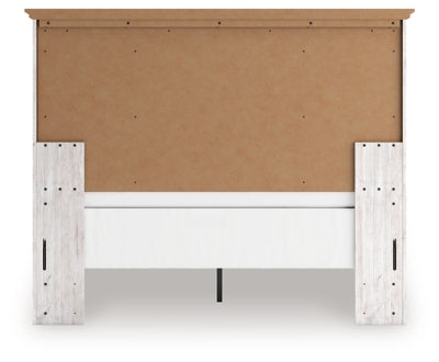 Ashley Furniture Makidern Bed with a dark wood frame and upholstered headboard, shown from the back.
