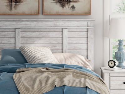 Ashley Furniture Makidern Bed with detailed wooden headboard and frame, showcasing a classic bedroom design.