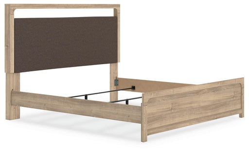 Ashley Furniture Kinlanni upholstered bed with a padded headboard and neutral fabric, shown from an angled side view.