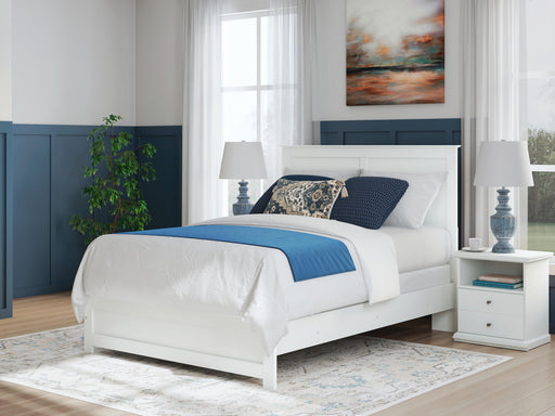 Ashley Furniture Bostwick Shoals Bed with a sturdy wooden frame and classic design, shown in a cozy bedroom setting.