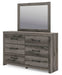 Ashley Furniture Graystorm bedroom set, includes bed, dresser, and nightstands, shown from an angled view in a modern bedroom.