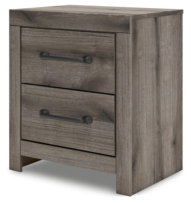 Graystorm bedroom set by Ashley Furniture, featuring a bed, nightstands, and dresser in a modern gray finish, shown from an angle.