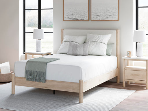 Ashley Furniture Cadmori upholstered bed with a plush headboard and neutral fabric, showcasing elegant bedroom furniture design.