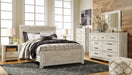 Ashley Furniture Bellaby Bed with a sleek frame and neutral upholstery, shown in a modern bedroom setting.