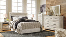 Ashley Furniture Bellaby Bed with a sturdy wooden frame and classic design, shown in a cozy bedroom setting.