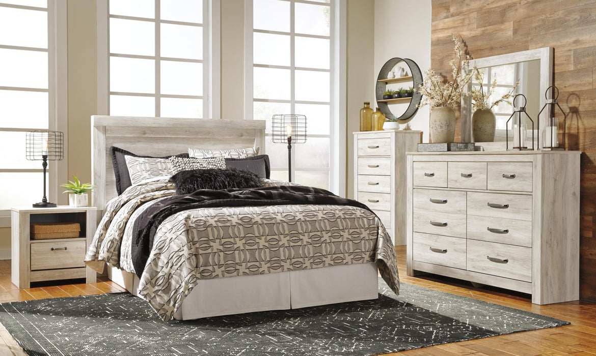Ashley Furniture Bellaby Bed with a sturdy wooden frame and classic design, shown in a well-lit bedroom setting.