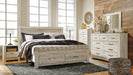 Ashley Furniture Bellaby Bed with a sturdy frame and classic design, shown with the headboard and footboard in a natural wood finish.
