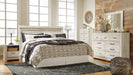 Ashley Furniture Bellaby Bed with a sturdy wooden frame and classic design, shown in a cozy bedroom setting.