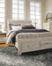 Ashley Furniture Bellaby Bed with upholstered headboard and wooden frame, shown in a modern bedroom setting.