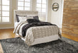 Ashley Furniture Bellaby Bed with upholstered headboard and wooden frame, shown in a modern bedroom setting.