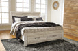 Ashley Furniture Bellaby Bed with elegant wood frame and neutral upholstery, showcasing a stylish bedroom centerpiece.
