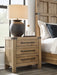 Ashley Furniture Ridgester nightstand with a sleek wooden finish and modern design, featuring drawer storage and a flat top surface.