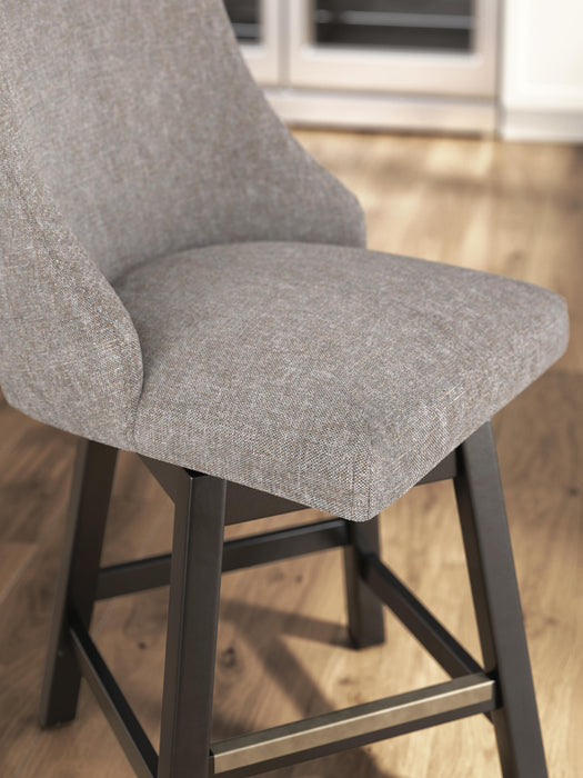 Ashley Furniture Neymorton counter height barstool with wooden legs and upholstered seat, shown from a detailed side view.