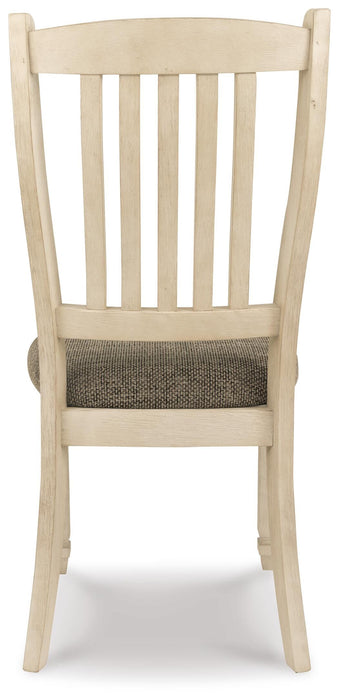 Ashley Furniture Bolanburg dining room set with a table and six chairs, shown from the back view in a modern dining space.