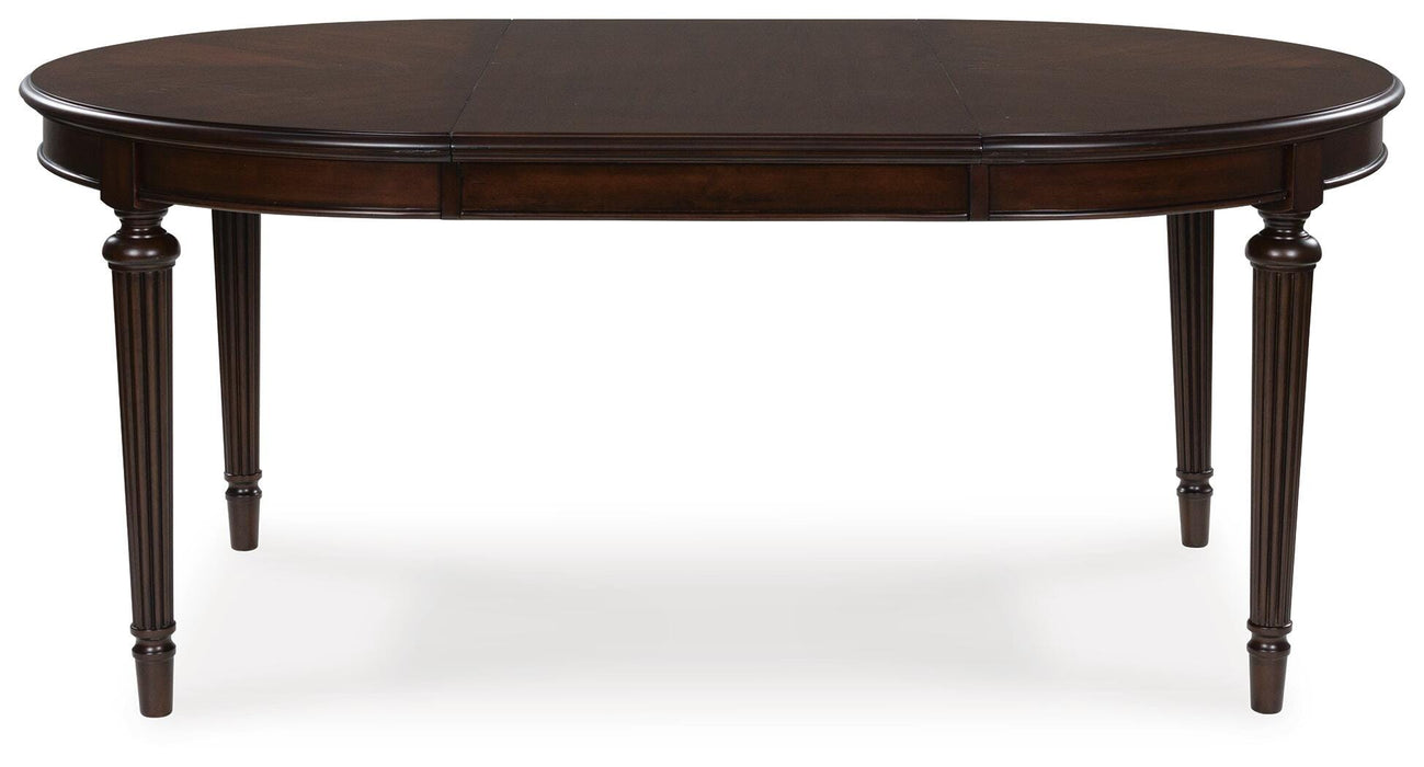 Ashley Furniture Lavinton dining room set with a table and matching chairs featuring leaf pattern accents, shown from a head-on angle.