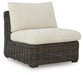 Ashley Furniture Kimora outdoor sectional with beige cushions and dark metal frame, arranged for relaxing outdoor seating.