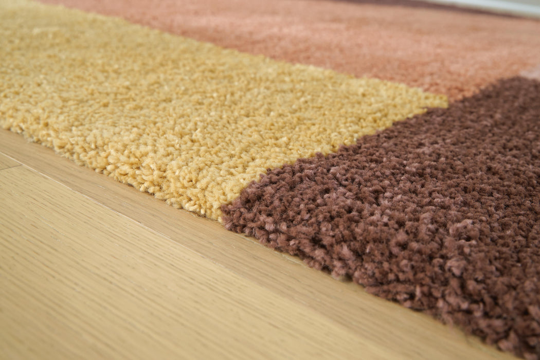 Close-up of the Ashley Furniture Gailmore Rug featuring intricate patterns and soft textures in warm neutral tones.