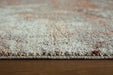 Close-up of Ashley Furniture Jadenburg Rug featuring intricate patterns and textured fabric in neutral tones.